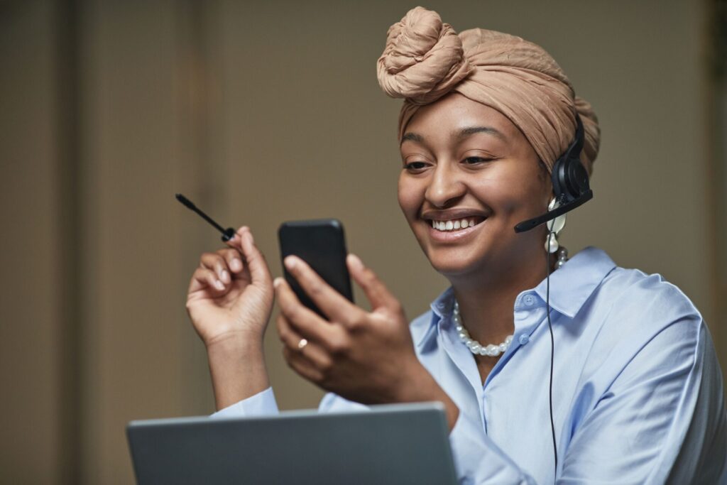 Colaboradora vendo no celular a experiência que recebeu como premiação da empresa